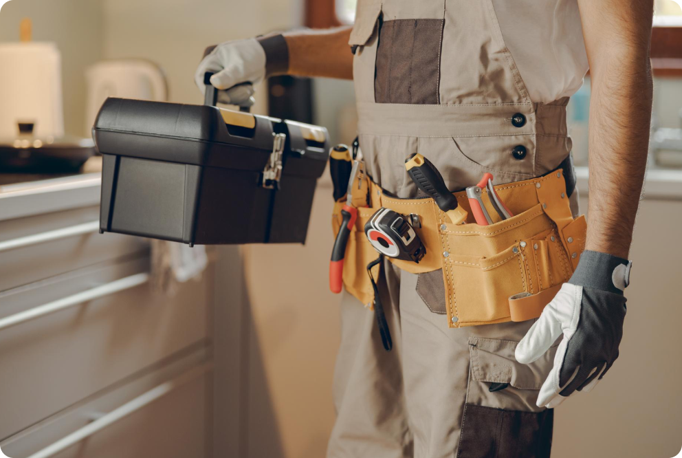Handwerker mit Werkzeugtasche bei Reparaturarbeiten im Innenbereich