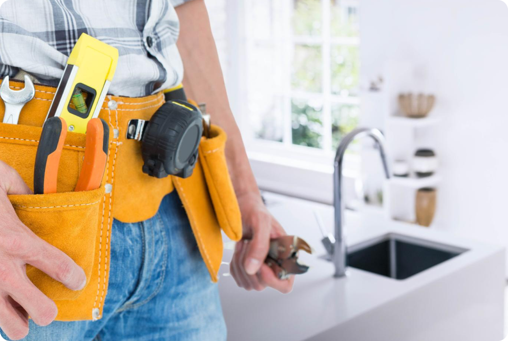 Ein Installateur arbeitet an einem Wasseranschluss in der Küche